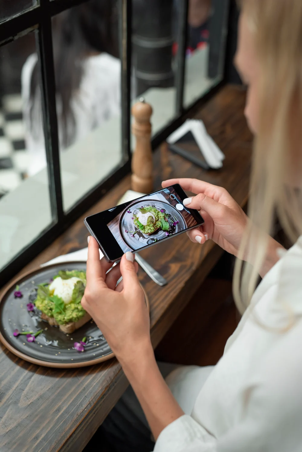 A guest photographing their plate at the table